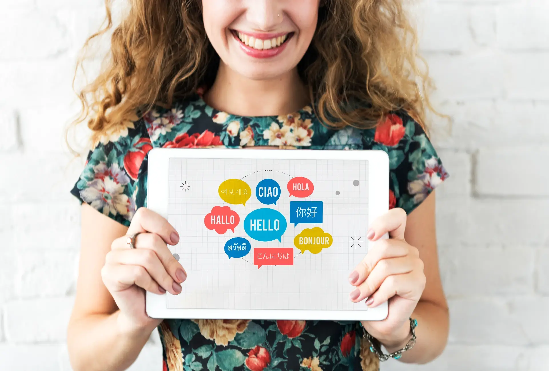 Junge Frau zeigt Tablet mit Hallo in verschiedenen Sprachen